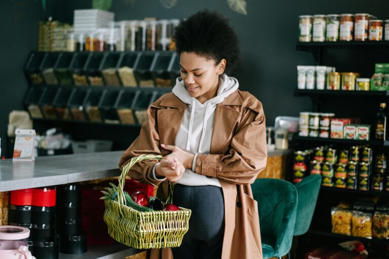 A pregnant woman shops for fresh vegetables at an organic grocery store.