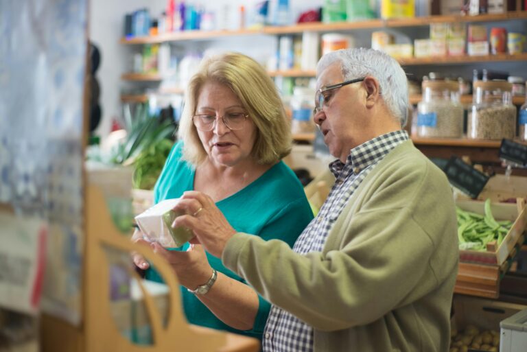An elderly couple explores products inside a local store in Portugal, highlighting everyday life.